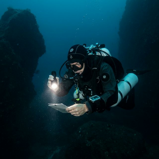 Дайвер на глубине с фонарём